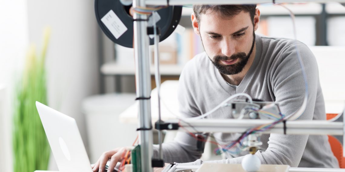 Young designer engineer using a 3D printer in the laboratory and studying a product prototype, technology and innovation concept