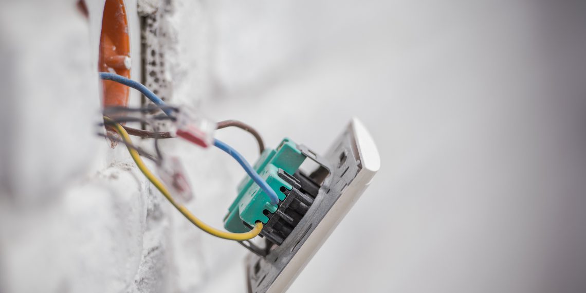 Electric Outlet Installation Closeup Photo. Concrete Brick Wall Outlet.