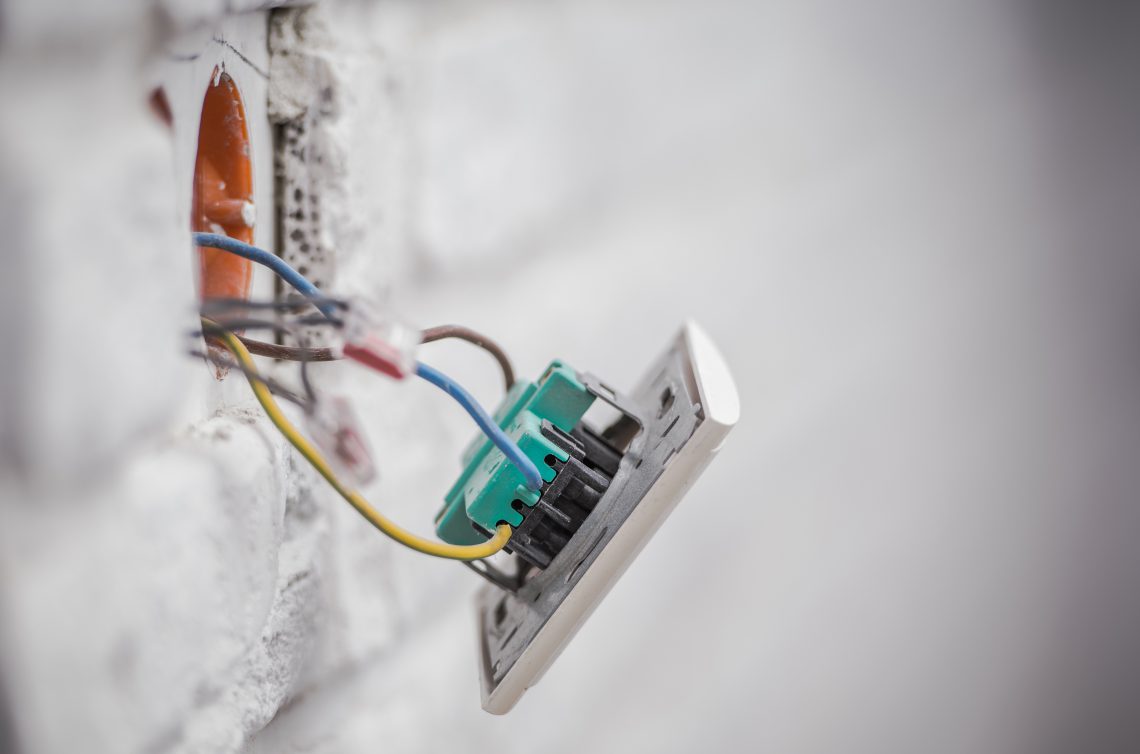 Electric Outlet Installation Closeup Photo. Concrete Brick Wall Outlet.