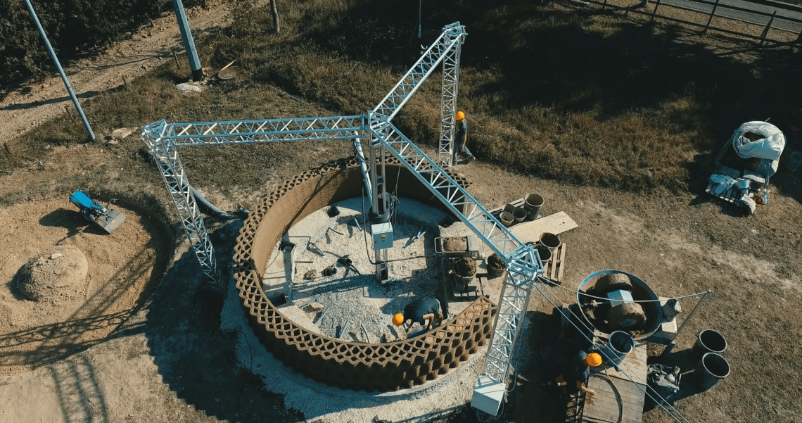 Overhead view of GAIA construction site with a delta style construction 3D printer. Photo curtesy of WASP.